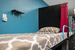 Hostel bunk bed with privacy curtain and personal outlet at California Dreams Hostel
