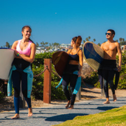 Travelers carrying surfboards near the beach in San Diego