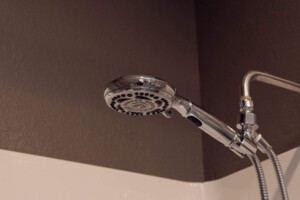 Modern showerhead in a clean private shower at California Dreams Hostel